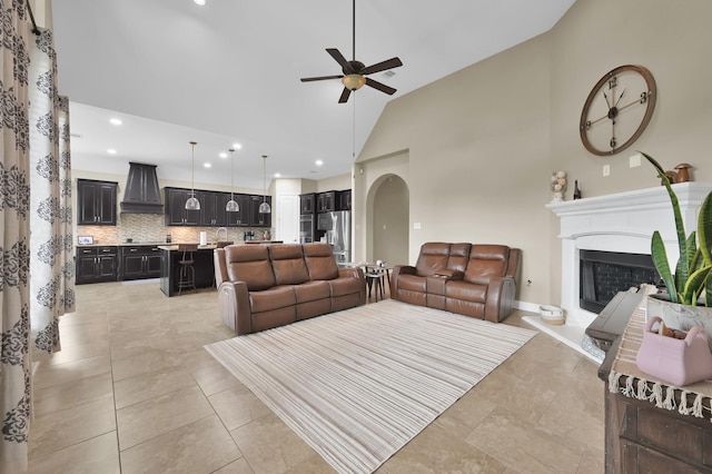 116 Owen Ridge Dr, Conroe, TX 77384 - living room featuring a ceiling fan, a fireplace with raised hearth, arched walkways, high vaulted ceiling, and recessed lighting