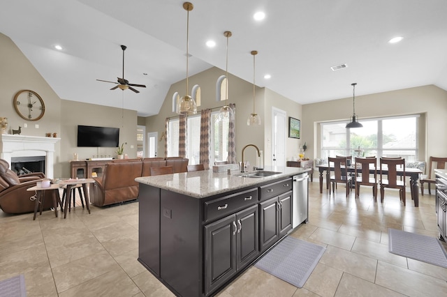 116 Owen Ridge Dr, Conroe, TX 77384 - kitchen featuring stainless steel dishwasher, a sink, vaulted ceiling, light tile patterned flooring, and a fireplace