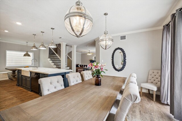 1310 Cohn St, Houston, TX 77007 - dining room with wood finished floors, stairway, crown molding, ornate columns, and a chandelier