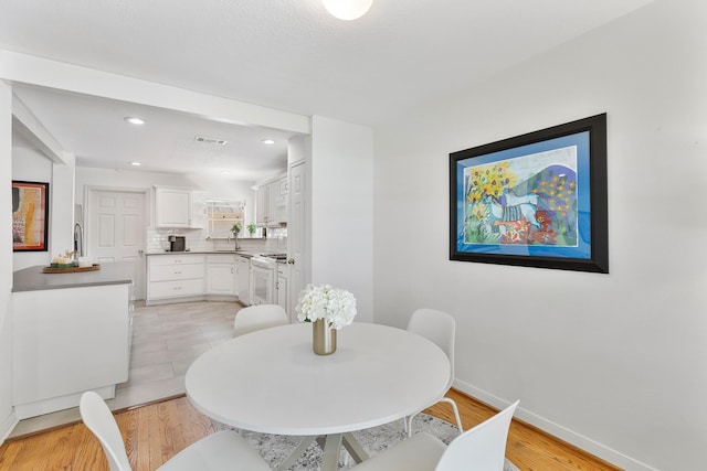 3923 W Main St, Houston, TX 77027 - dining area with baseboards, light wood-style flooring, and recessed lighting
