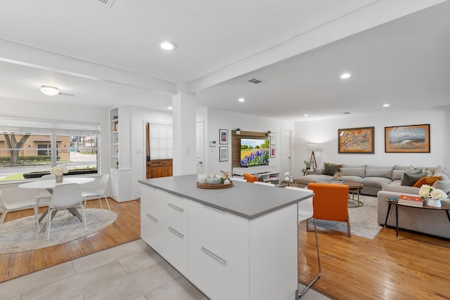3923 W Main St, Houston, TX 77027 - kitchen with modern cabinets, a kitchen island, white cabinets, recessed lighting, and light tile patterned floors