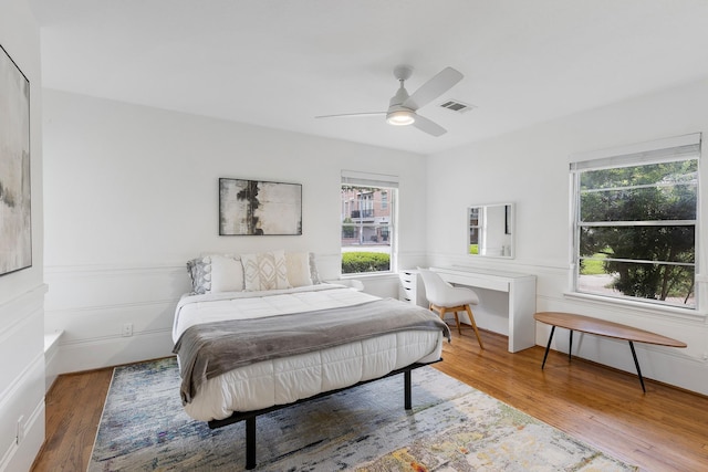 3923 W Main St, Houston, TX 77027 - bedroom with multiple windows, wood finished floors, and ceiling fan