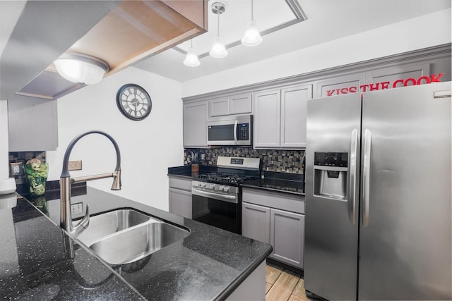 13031 Crystal Cove Dr, Houston, TX 77044 - kitchen featuring stainless steel appliances, gray cabinetry, tasteful backsplash, and decorative light fixtures