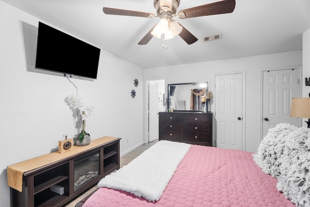13031 Crystal Cove Dr, Houston, TX 77044 - bedroom with two closets, wood finished floors, and a ceiling fan