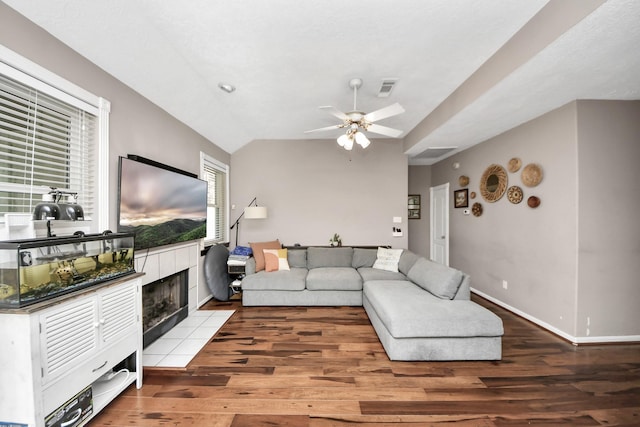 23227 Diamond Knoll Ct, Katy, TX 77494 - living area with a tiled fireplace, wood finished floors, a ceiling fan, and vaulted ceiling