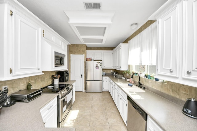 23227 Diamond Knoll Ct, Katy, TX 77494 - kitchen with appliances with stainless steel finishes, white cabinets, light countertops, and backsplash