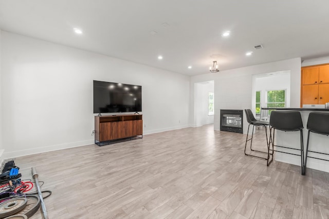 4313 Windswept Dr, Montgomery, TX 77356 - living room featuring light wood-style floors, a glass covered fireplace, and recessed lighting