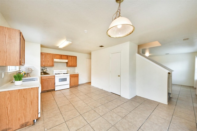 22815 Sherioaks Ln, Spring, TX 77389 - kitchen featuring white range, under cabinet range hood, light countertops, light tile patterned floors, and a sink