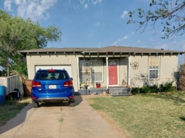 1311 Lamar Ave, Big Spring, TX 79720 - ranch-style home with driveway, a garage, a front yard, and stucco siding