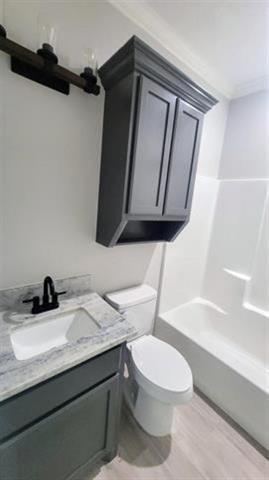 3090 Ethan Symone St, Beaumont, TX 77705 - full bathroom featuring vanity, shower / bath combination, and wood finished floors