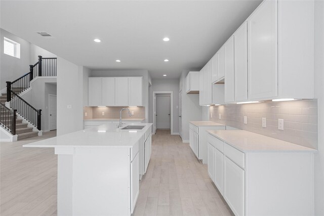 2008 Sugarberry Gully Ln, Conroe, TX 77301 - kitchen with a sink, light wood-type flooring, decorative backsplash, recessed lighting, and a kitchen island with sink