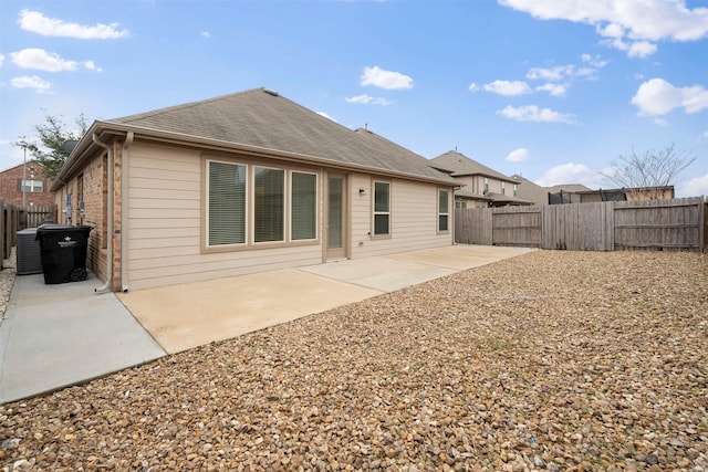24018 Adobe Ridge Ln, Katy, TX 77493 - back of house featuring a fenced backyard, a patio area, roof with shingles, central AC, and brick siding