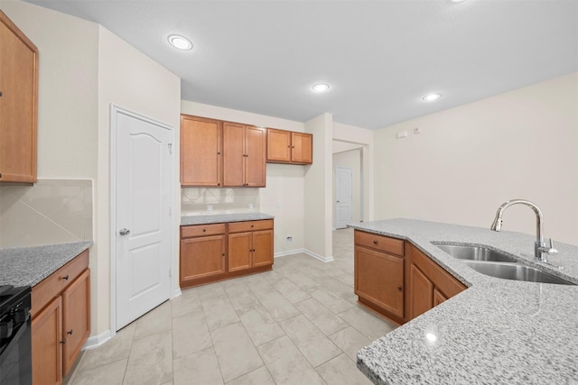 24018 Adobe Ridge Ln, Katy, TX 77493 - kitchen with a sink, brown cabinetry, backsplash, light stone countertops, and recessed lighting