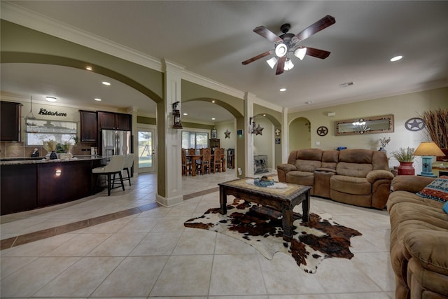 3077 Dees Cir, Sealy, TX 77474 - living room with arched walkways, a ceiling fan, healthy amount of natural light, light tile patterned floors, and crown molding