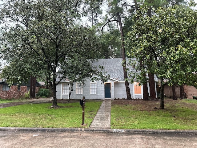 22906 Lemon Grove Dr, Spring, TX 77373 - view of front of home featuring a front lawn, brick siding, and a shingled roof
