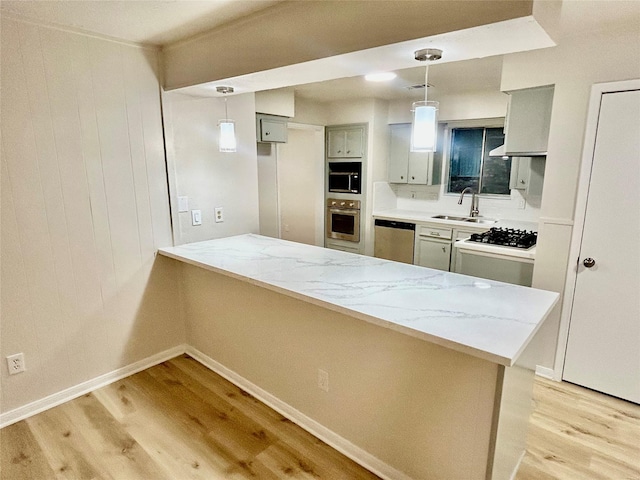 22906 Lemon Grove Dr, Spring, TX 77373 - kitchen featuring light wood-type flooring, a peninsula, dishwasher, gas cooktop, and light stone countertops