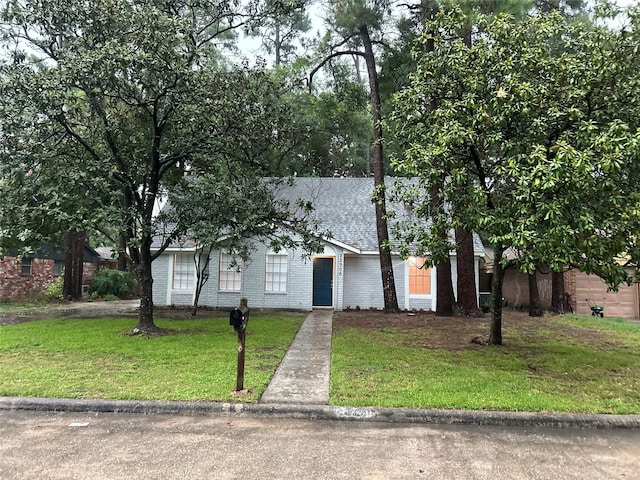 22906 Lemon Grove Dr, Spring, TX 77373 - view of property hidden behind natural elements with a front lawn, brick siding, and a shingled roof