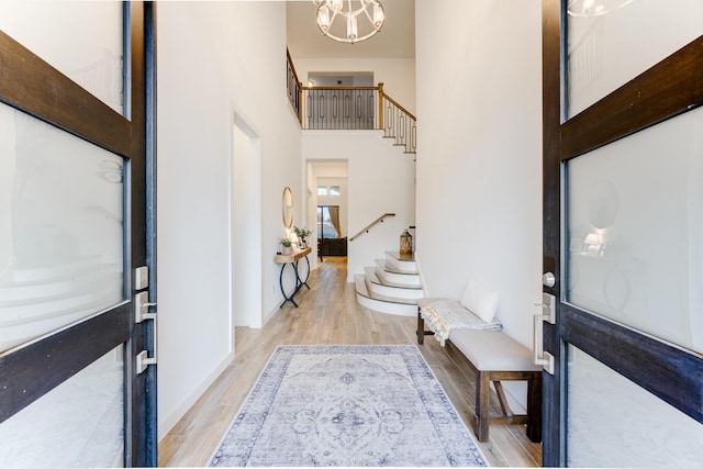 4222 Ana Ridge Ln, Fulshear, TX 77441 - foyer with stairs, light wood-style flooring, a towering ceiling, a chandelier, and baseboards