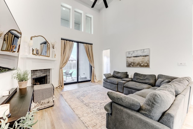 4222 Ana Ridge Ln, Fulshear, TX 77441 - living area with light wood-style floors, a high ceiling, a brick fireplace, and ceiling fan