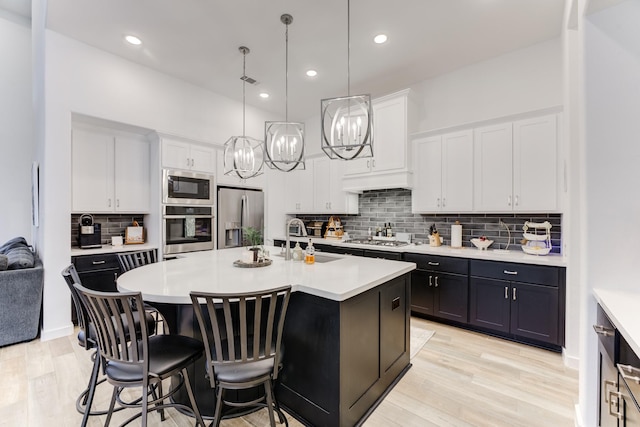 4222 Ana Ridge Ln, Fulshear, TX 77441 - kitchen featuring appliances with stainless steel finishes, a sink, light countertops, a kitchen breakfast bar, and white cabinetry