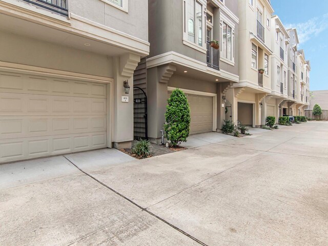 4133 Dickson St, Houston, TX 77007 - doorway to property with a garage, stucco siding, and driveway