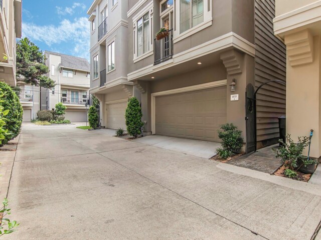 4133 Dickson St, Houston, TX 77007 - view of side of home featuring a garage, stucco siding, and driveway