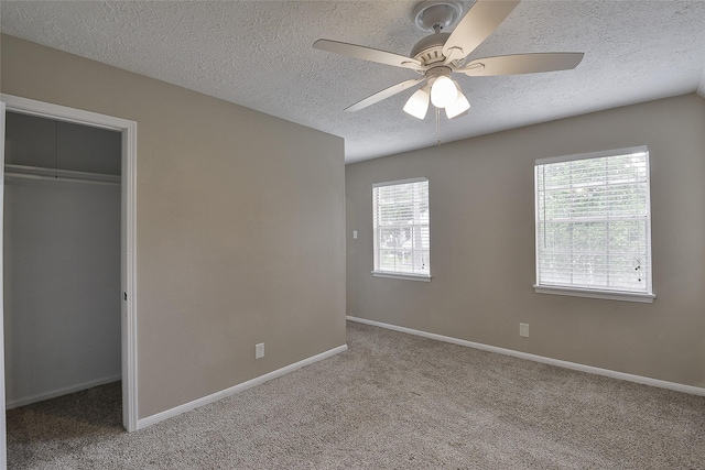 5411 Mossy Timbers Dr, Humble, TX 77346 - unfurnished bedroom with a textured ceiling, carpet floors, a closet, ceiling fan, and a walk in closet