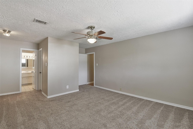 5411 Mossy Timbers Dr, Humble, TX 77346 - unfurnished bedroom with carpet, a ceiling fan, ensuite bath, and a textured ceiling