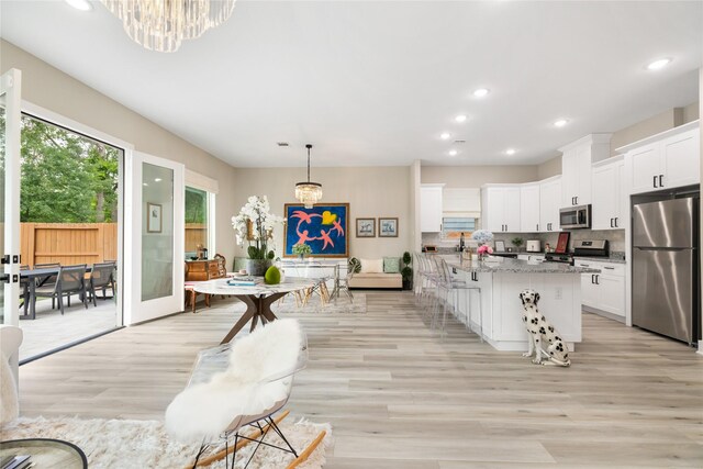 4926 Wunder Way, Houston, TX 77069 - kitchen with appliances with stainless steel finishes, a chandelier, light wood-style flooring, white cabinetry, and recessed lighting