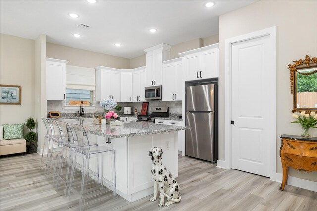 4926 Wunder Way, Houston, TX 77069 - kitchen featuring stainless steel appliances, light wood-style floors, backsplash, a kitchen island, and recessed lighting