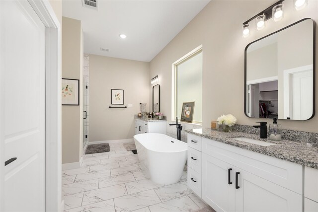 4926 Wunder Way, Houston, TX 77069 - bathroom featuring marble look tiles, two vanities, a shower stall, a freestanding bath, and recessed lighting