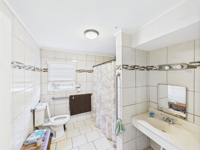 1429 S Mathis St, Rockport, TX 78382 - bathroom with tile walls, toilet, tile patterned flooring, curtained shower, and a sink