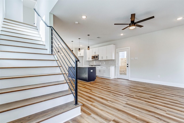 5407 Lee St, Houston, TX 77020 - stairs with a ceiling fan, wood finished floors, recessed lighting, and baseboards