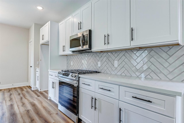 5407 Lee St, Houston, TX 77020 - kitchen with stainless steel appliances, decorative backsplash, white cabinetry, light wood-style flooring, and recessed lighting