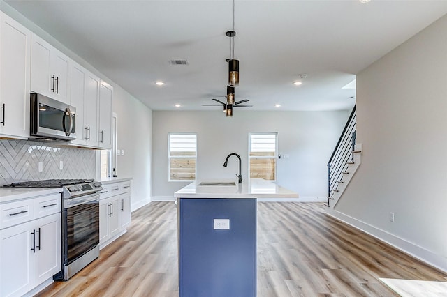 5407 Lee St, Houston, TX 77020 - kitchen with appliances with stainless steel finishes, a sink, light wood-type flooring, baseboards, and decorative backsplash