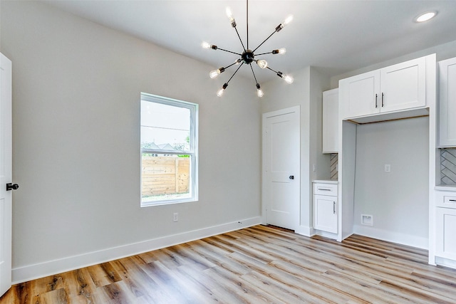 5407 Lee St, Houston, TX 77020 - kitchen with a chandelier, light wood-style flooring, white cabinetry, light countertops, and recessed lighting