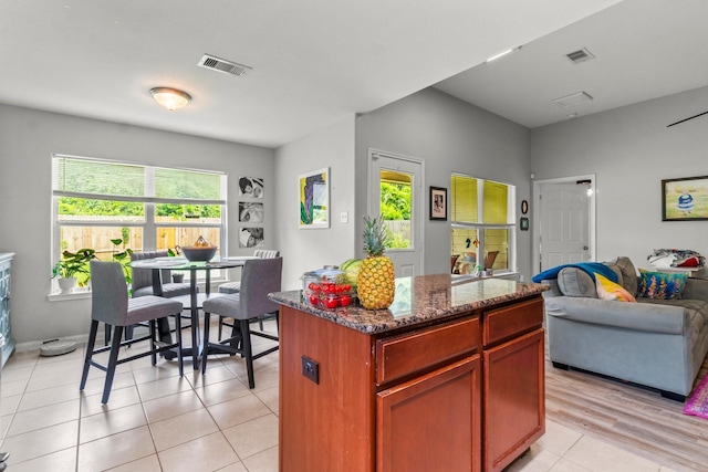 12218 Estelle Ln, Pinehurst, TX 77362 - kitchen featuring healthy amount of natural light, open floor plan, a kitchen island, and dark stone countertops