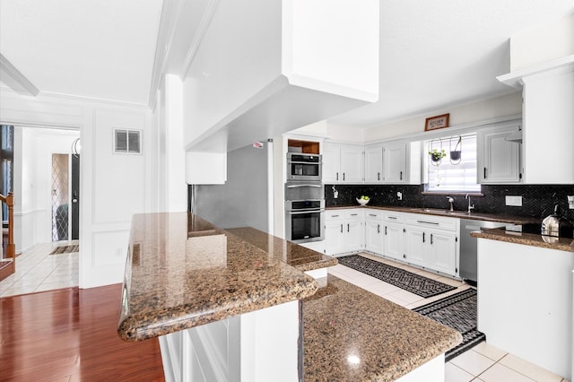 3602 Highland Lakes Dr, Kingwood, TX 77339 - kitchen featuring appliances with stainless steel finishes, light tile patterned flooring, a sink, decorative backsplash, and ornamental molding