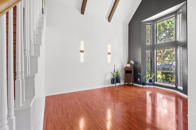 3602 Highland Lakes Dr, Kingwood, TX 77339 - unfurnished living room with high vaulted ceiling, wood finished floors, beam ceiling, and baseboards