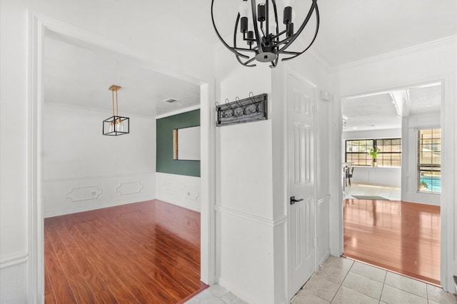 3602 Highland Lakes Dr, Kingwood, TX 77339 - hall featuring a chandelier, crown molding, light wood finished floors, and a wainscoted wall