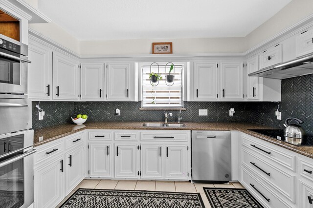 3602 Highland Lakes Dr, Kingwood, TX 77339 - kitchen with stainless steel appliances, a sink, light tile patterned flooring, white cabinets, and dark stone countertops