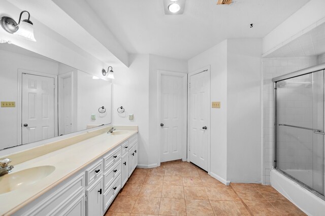 3602 Highland Lakes Dr, Kingwood, TX 77339 - bathroom featuring double vanity, combined bath / shower with glass door, baseboards, and tile patterned flooring
