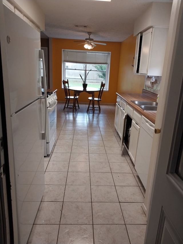 2450 Edgedale Dr, Missouri City, TX 77489 - kitchen with white appliances, light tile patterned flooring, white cabinets, and a ceiling fan