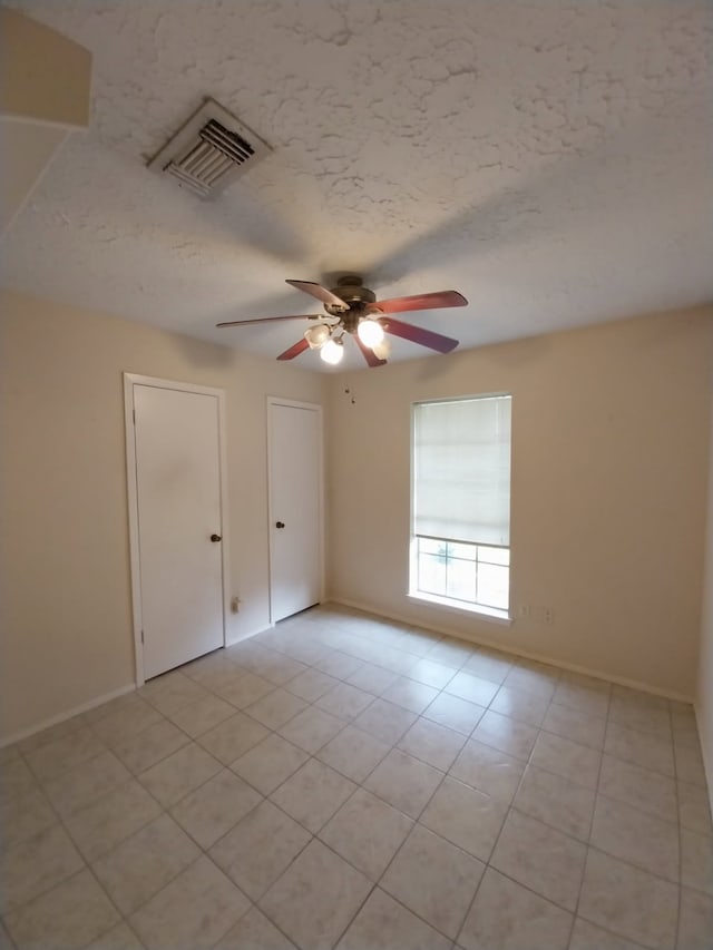 2450 Edgedale Dr, Missouri City, TX 77489 - empty room with ceiling fan, a textured ceiling, and light tile patterned floors