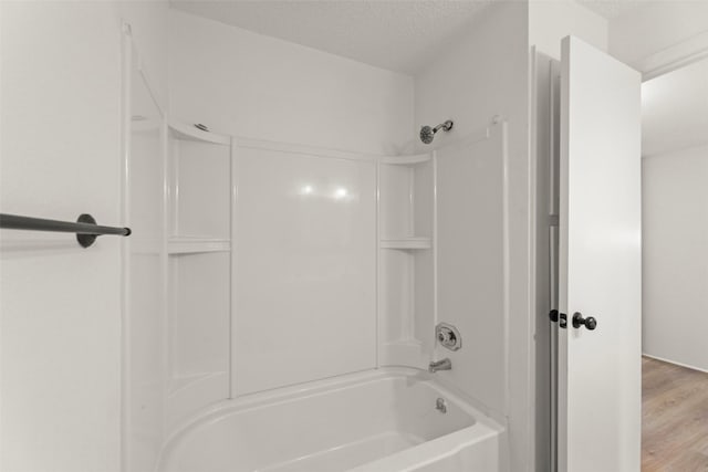 8101 Amelia Rd Unit 106, Houston, TX 77055 - full bathroom featuring washtub / shower combination, wood finished floors, and a textured ceiling