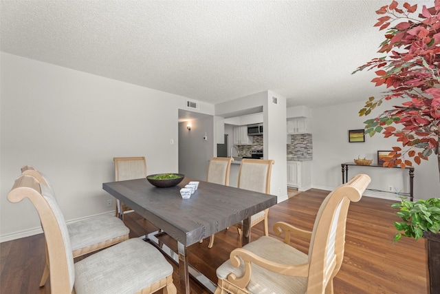 8101 Amelia Rd Unit 106, Houston, TX 77055 - dining area featuring a textured ceiling, wood finished floors, and baseboards