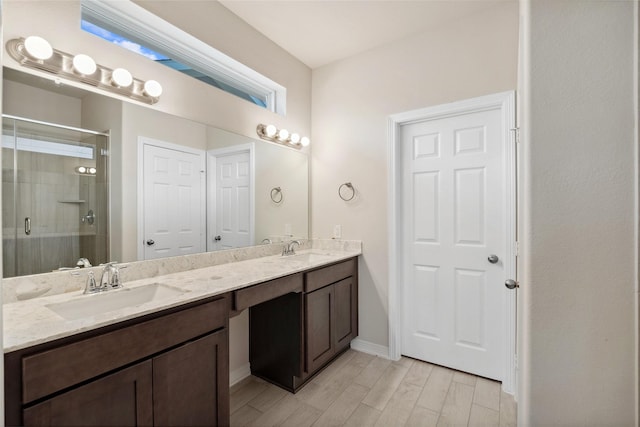 329 Bay Oaks St, La Porte, TX 77571 - bathroom with double vanity, a shower stall, wood tiled floors, and baseboards