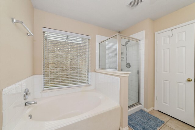 8123 Solara Bnd, Houston, TX 77083 - bathroom featuring a bath, a shower stall, and tile patterned flooring