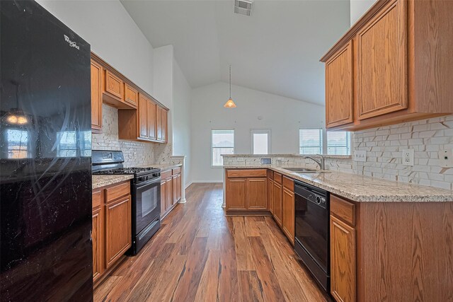 19826 Imperial Stone Dr, Houston, TX 77073 - kitchen with black appliances, a sink, wood finished floors, lofted ceiling, and backsplash