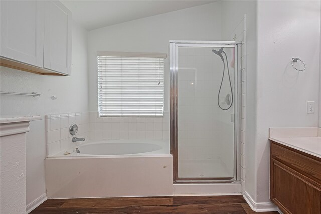 19826 Imperial Stone Dr, Houston, TX 77073 - bathroom with wood finished floors, a bath, a stall shower, vaulted ceiling, and vanity